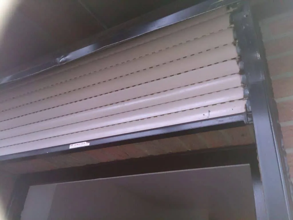 Ein teilweise geschlossener Rollladen über einem Fenster.