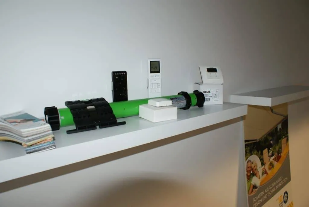 Verschiedene Netzwerkgeräte auf einem weißen Regal ausgestellt.