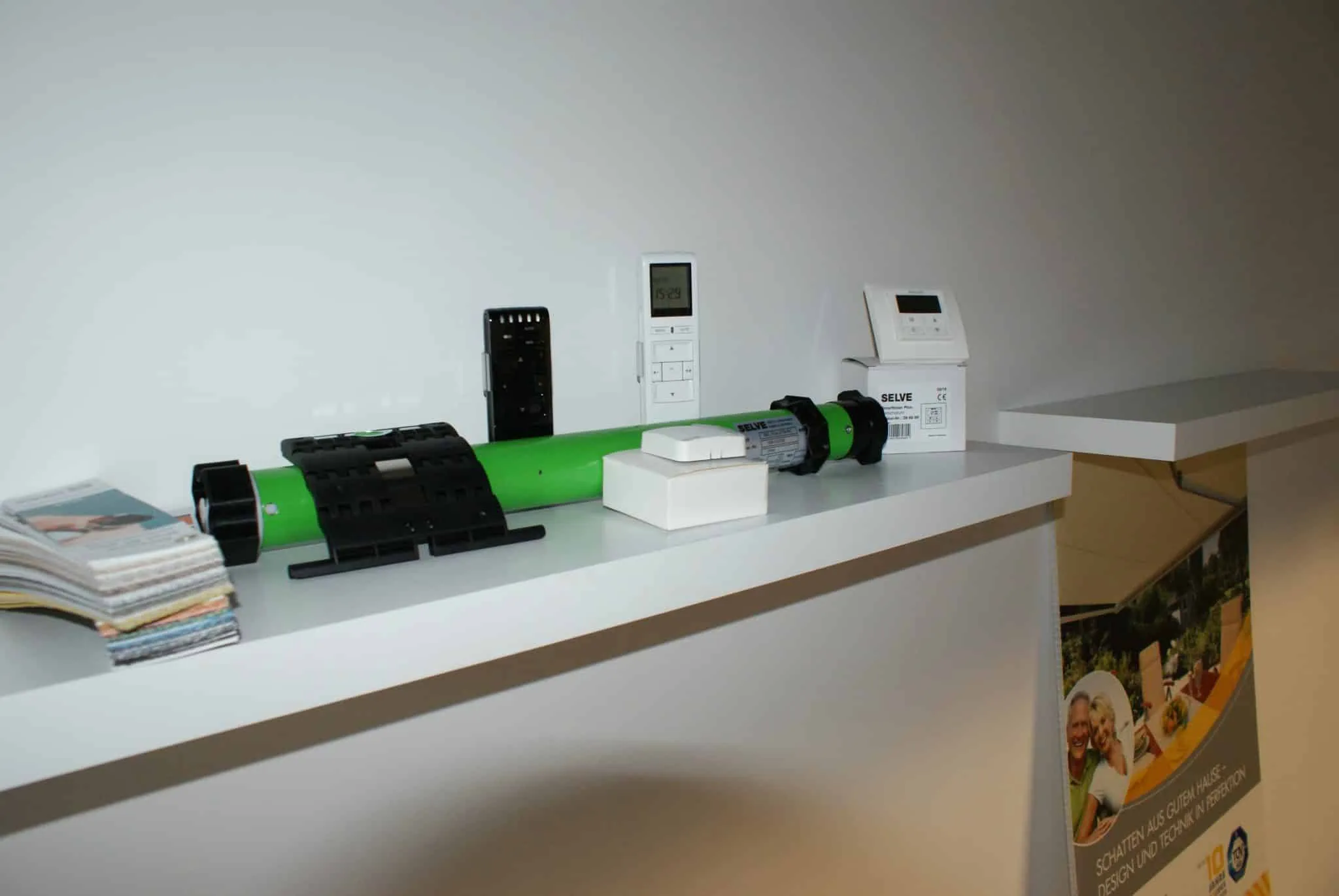 Verschiedene Netzwerkgeräte auf einem weißen Regal ausgestellt.