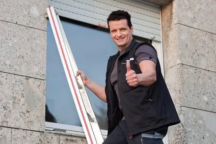 Mann zeigt einen Daumen nach oben, während er eine Leiter trägt.